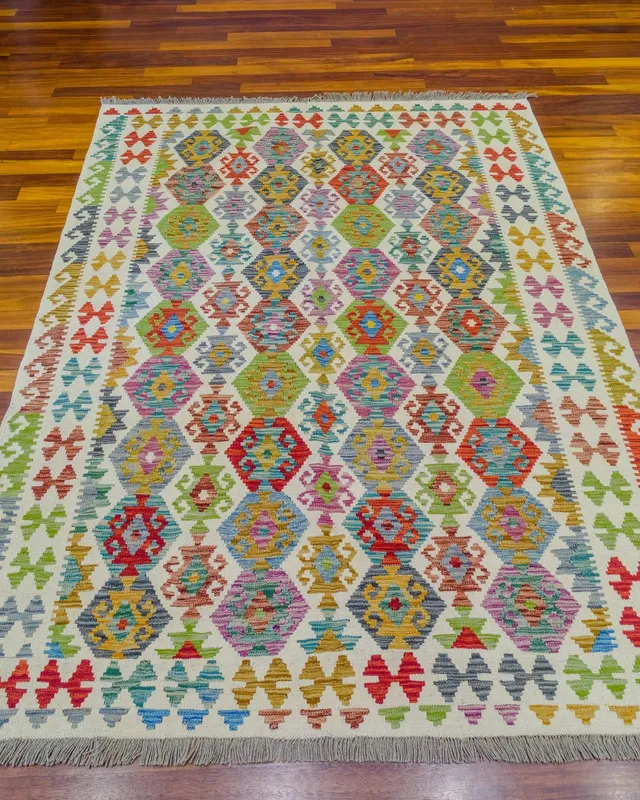 Krem zeminli, sıra sıra çok renkli altıgen motifli, gri püsküllü kilim